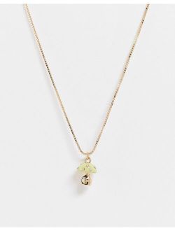 necklace with green mushroom pendant in gold tone