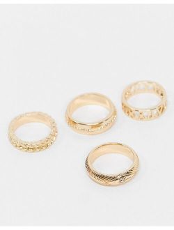 pack of 4 rings in mixed texture and cut-out roman numerals in gold tone