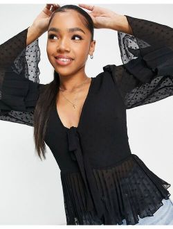 textured pleated peplum top with button and tie detail with long sleeve in black