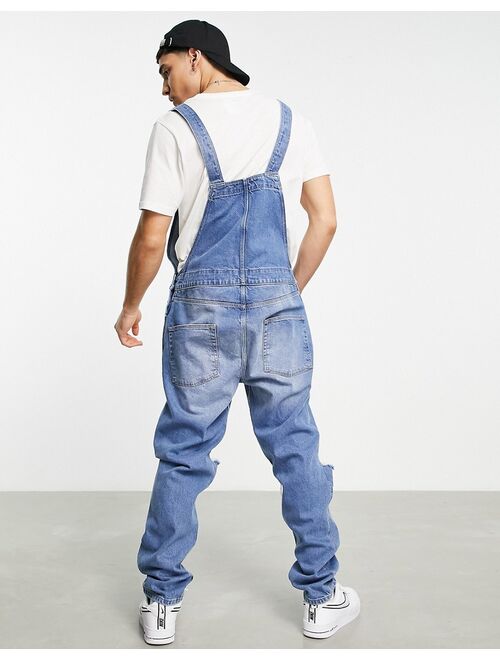 ASOS DESIGN denim overalls in mid wash with knee rips