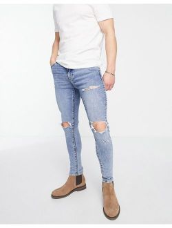 spray on jeans with power stretch in mid wash with knee rips and abrasions