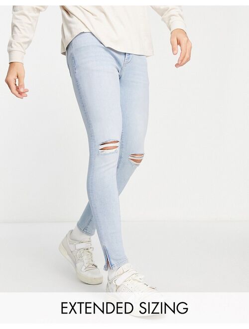 ASOS DESIGN spray on jeans in power stretch in light wash with knee rips and zip hem
