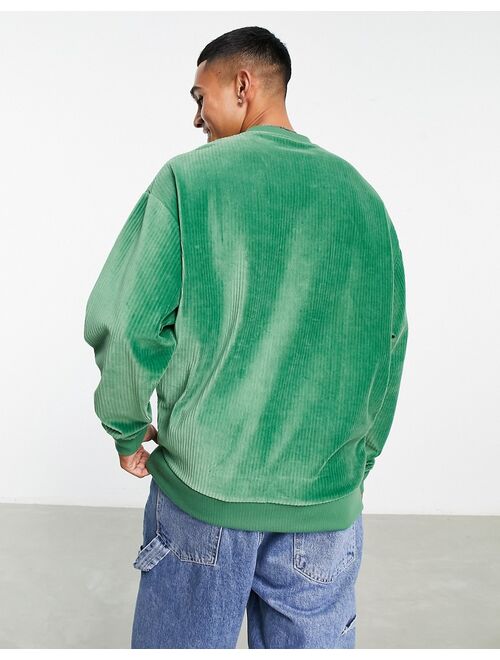 ASOS DESIGN oversized sweatshirt in green ribbed velour with varsity badge