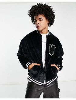 oversized varsity faux fur jacket in black with badge and tipping