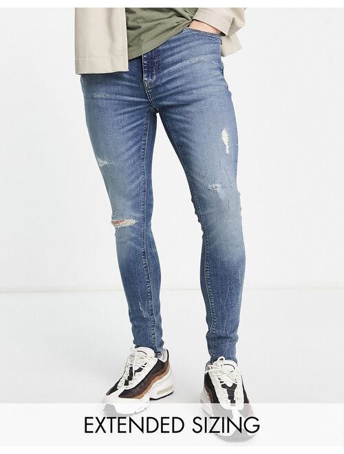 ASOS DESIGN spray on jeans with power stretch in mid wash blue with tint and abrasions