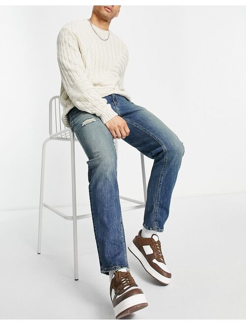 ASOS DESIGN stretch tapered jeans in tinted wash with abrasions