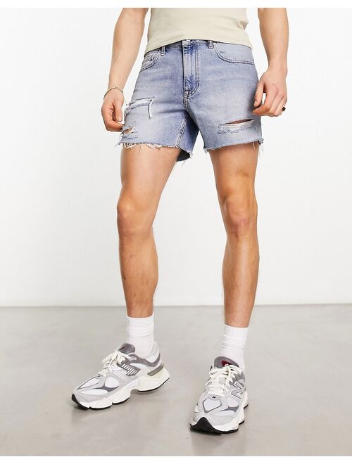 ASOS DESIGN shorter length denim shorts with rips in light wash blue