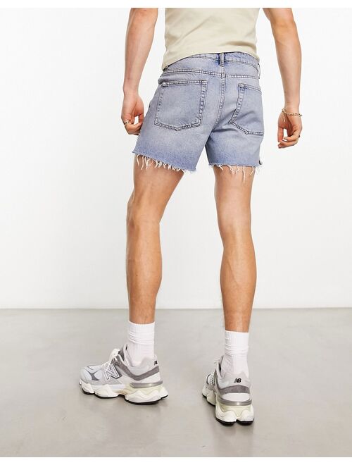 ASOS DESIGN shorter length denim shorts with rips in light wash blue
