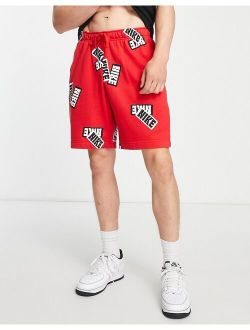 Sport Essentials all over sticker print fleece shorts in red