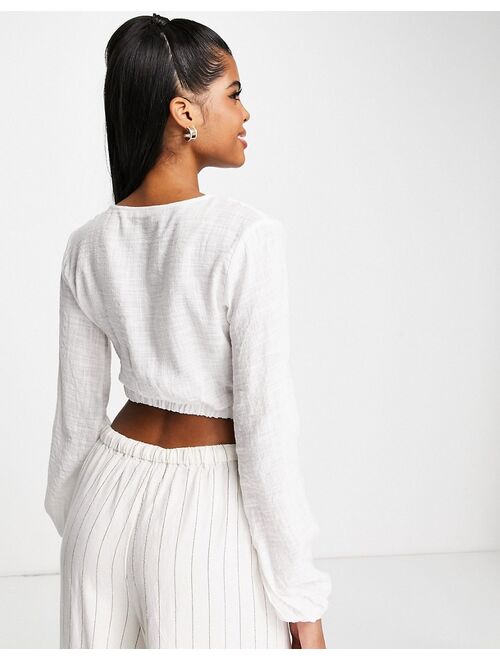 Pull&Bear rustic long sleeve cut out wrap front cropped top in off white