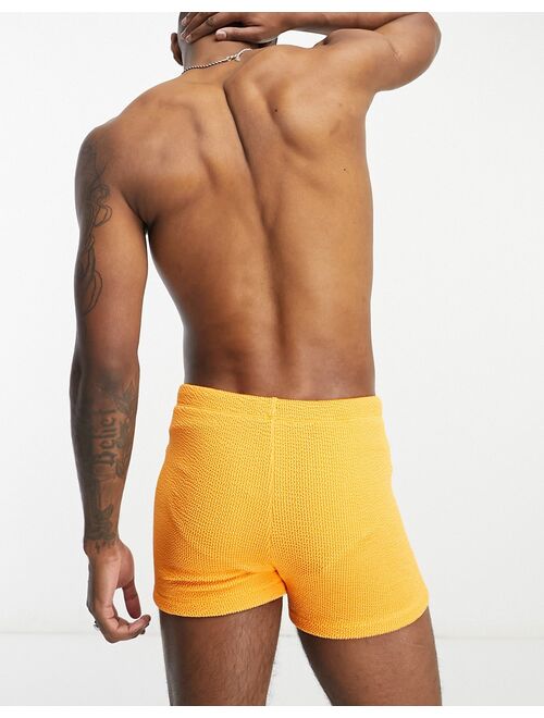 ASOS DESIGN textured swim trunks in orange