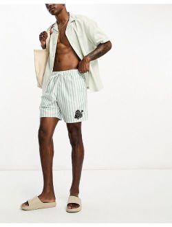 swim shorts in short length in stripe with fish placement