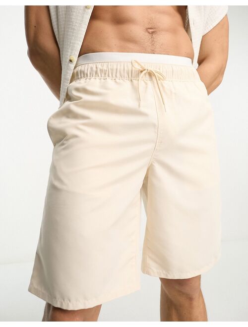 ASOS DESIGN swim shorts in long length with double waistband in beige