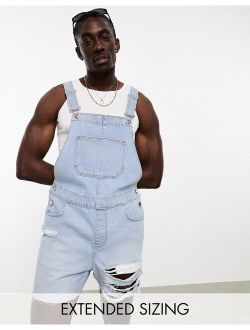overalls in light wash blue with heavy rips in shorter length