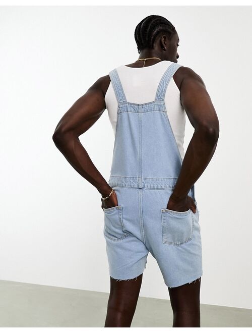 ASOS DESIGN overalls in light wash blue with heavy rips in shorter length