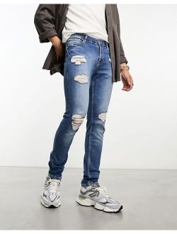 skinny jeans with rips in mid wash blue