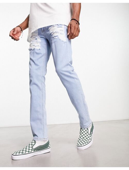 ASOS DESIGN skinny jeans with heavy rips in light wash blue