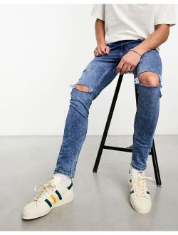 skinny jeans with knee rips in mid wash blue