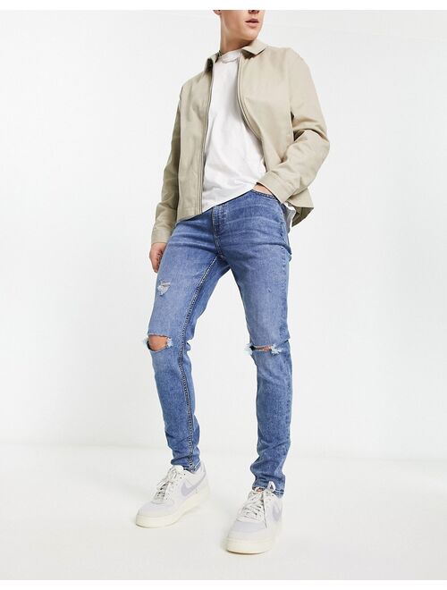 ASOS DESIGN skinny jeans in mid wash blue with rips