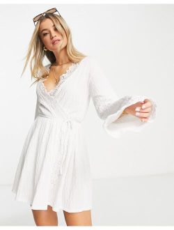 textured long sleeve mini wrap dress with crochet trim in white