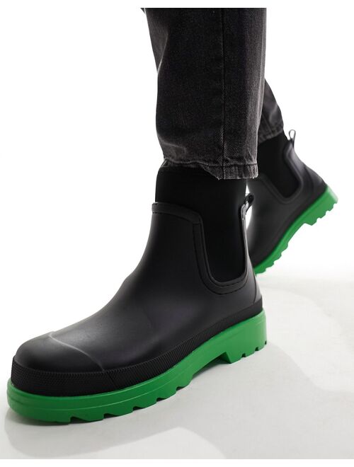 ASOS DESIGN chelsea wellington boots in black with green contrast sole