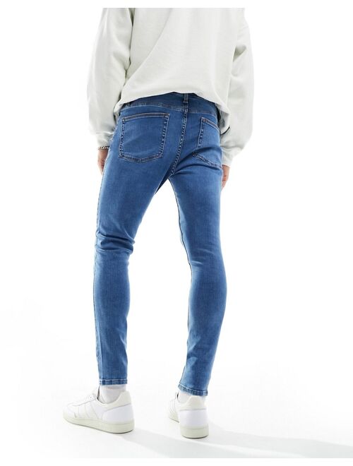 ASOS DESIGN spray on jeans with power stretch in mid wash blue